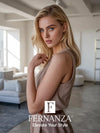 Uma mulher loira modelando um vestido sem mangas da cor taupe com um cinto marrom.